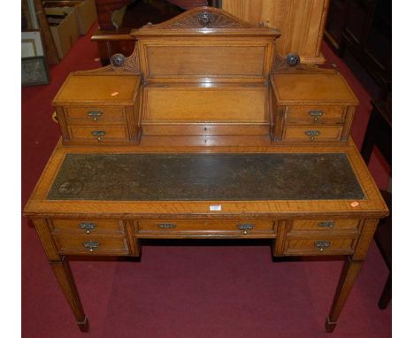 A good late Victorian light oak ledgeback writing desk, the raised superstructure with hinged stationery compartment, flanked