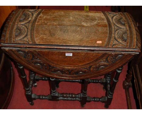 An early 20th century floral relief carved oak drop flap gate leg occasional table