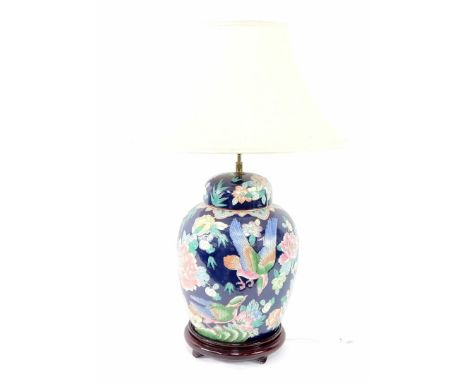 A Chinese porcelain lamp base, decorated with flowers and birds, and with a beige silk shade, 80cm high overall.