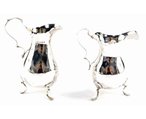 Two Edward VII silver milk jugs, with a flared rim on loop handle with tripod shell acanthus feet, Birmingham 1901, each 10cm