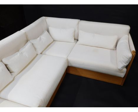 A modular pine sofa, upholstered in pattern cream fabric, with leather ties, in three sections. The upholstery in this lot do