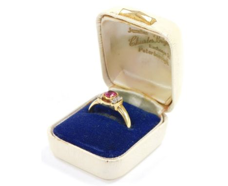 A ruby and diamond ring, the claw set oval cut ruby flanked by shoulders, each set with three diamonds, in yellow metal, stam