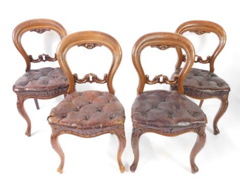 A set of four Victorian mahogany balloon back dining chairs, with over stuffed button red leather seats, raised on cabriole l