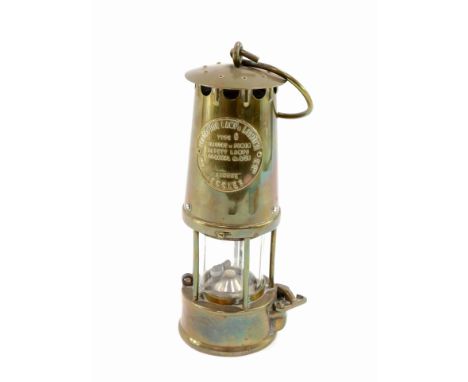 A brass Protector Lamp Company miner's lamp, 23cm high.