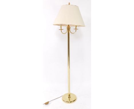 A brass effect standard lamp, with three shaped arms, on a domed foot, 170cm high.