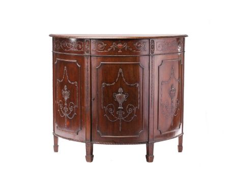 An Edwardian Adam-style mahogany demi-lune commode. With a single frieze drawer above a single panels door, with carved and a