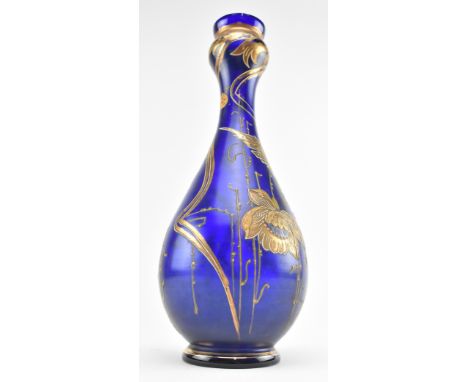 An early 20th century cobalt blue and gilded glass vase in the style of Moser. The vase with flaring rim over barrow neck and