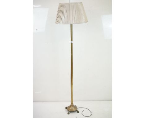 Brass Standard Lamp, the column raised on a circular base with four feet, with shade, 166cm to top of shade 
