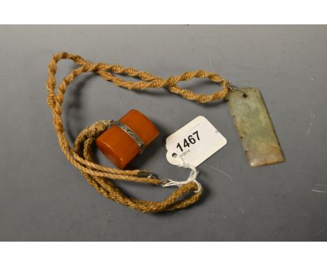 A Chinese amber toggle; a jade pendant (2)