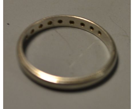 A nine stone diamond ring, central plain band set with a single row of nine round brilliant cut diamonds, within rope twist m