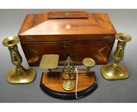 A set of postal scales, four graduated weights; a pair of brass candle sticks; a mahogany brass inlaid tea caddy (3)