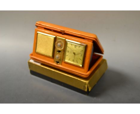 A retro 1950s/60s Estyma travelling radio alarm clock, tan leather case, original card box