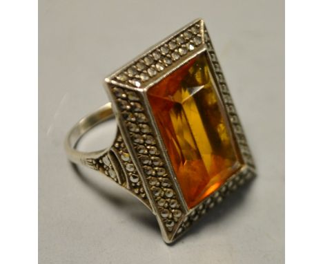 A large rectangular silver marcasite and amber coloured stone set dress ring.