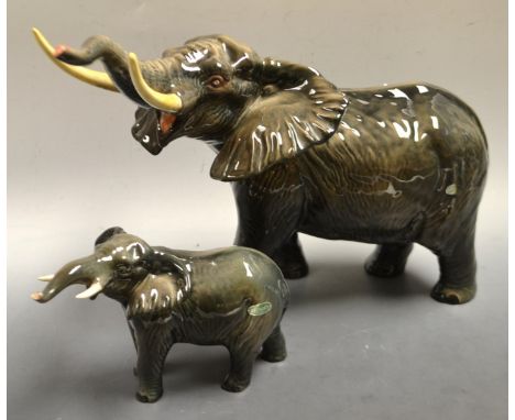 A large Beswick model of a bull elephant, trunk raised; another smaller (2)