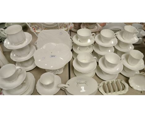 A Shelley tea set for six, glazed throughout in white, cups, saucers, tea plates, bread and butter plate, cake stand; others 