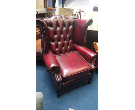 An Oxblood leather button back Chesterfield armchair