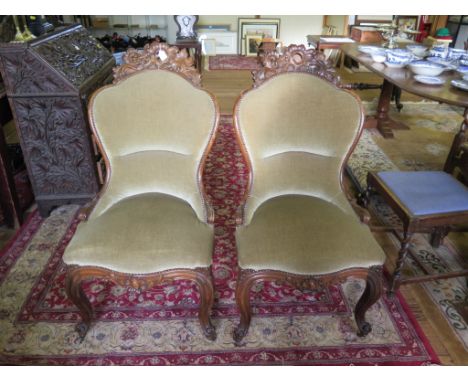 A pair of late 19th century French rosewood side chairs, the upholstered spoon backs with carved foliate top rails over cabri