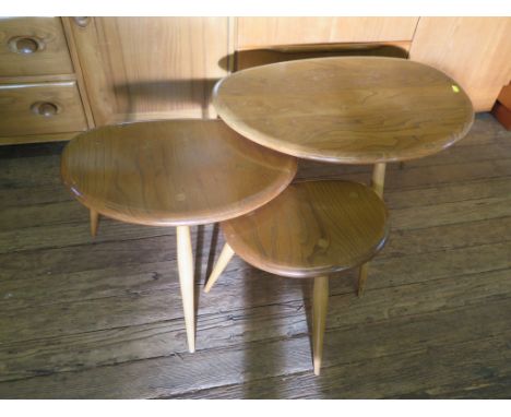 A nest of three Ercol pebble design ash and elm tables, largest 65cm wide, labelled 