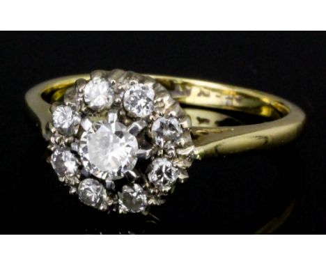 A modern 18ct gold and platinum mounted diamond flower head pattern ring, the central brilliant cut stone of approximately .2