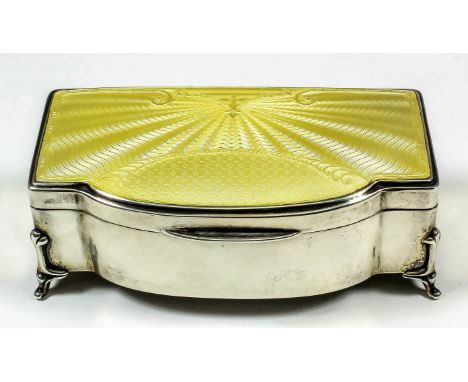 A George V silver rectangular bow front jewellery box with yellow guilloche enamel panel to top, cloth lined interior, on fou