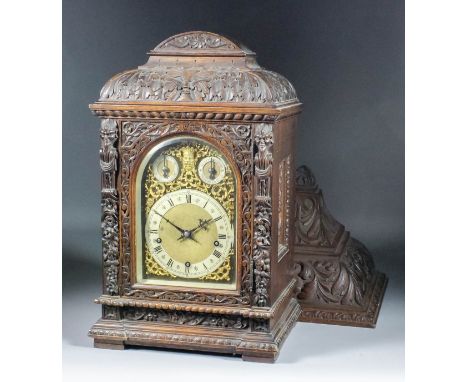 A late 19th Century German carved oak cased bracket clock and similar bracket, the 7ins arched brass dial with silvered chapt