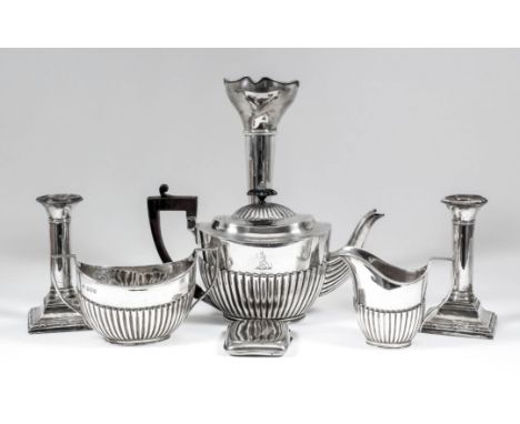 A late Victorian silver oval three piece tea service with part reeded bodies and angular loop handles, comprising - teapot wi