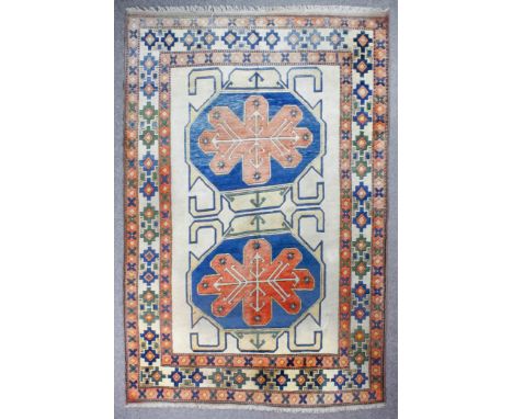 A modern Turkish carpet of "Kazak" design, woven in muted colours with two bold octagonal medallions filled and surrounded by