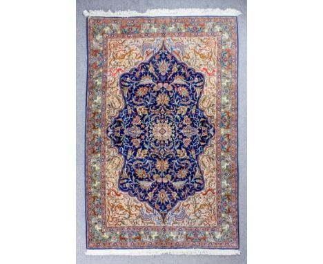 A good Tabriz carpet woven in colours with a shaped central medallion filled with palmettes and smaller medallion, on an navy