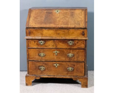 A George II walnut bureau of small proportions, the top, slope and drawer fronts inlaid with herringbone bandings, the slope 
