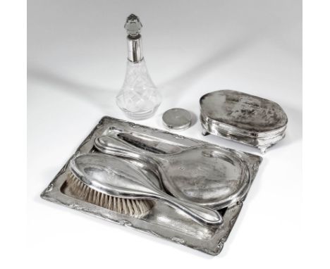 A George V silver rectangular tray with hammered finish, the rim cast with Art Nouveau scroll ornament and with plain oval ca