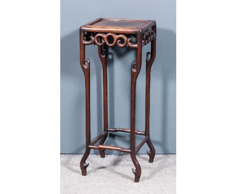 A Chinese hardwood square jardiniere stand with a recessed panel to top, scroll carved apron on turned legs and splayed toes,