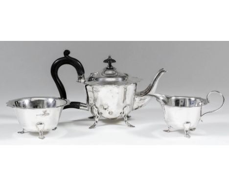 A George V silver circular three piece tea service with shaped rim, scroll handles and on scroll feet, comprising - teapot wi