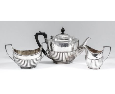 An Edward VII silver oval three piece tea service with part reeded bodies and angular loop handles, comprising - teapot with 