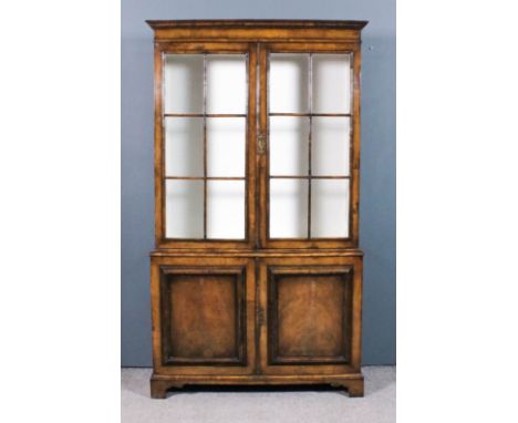 A 20th Century walnut bookcase of "18th Century" design, the upper part with moulded cornice, fitted two plate glass shelves 