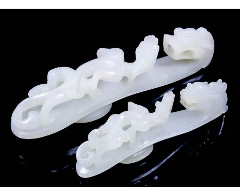 A Chinese white jade belt clip of scroll form, with carved dragons head to end and the body carved with a dragon, 3.75ins (9.