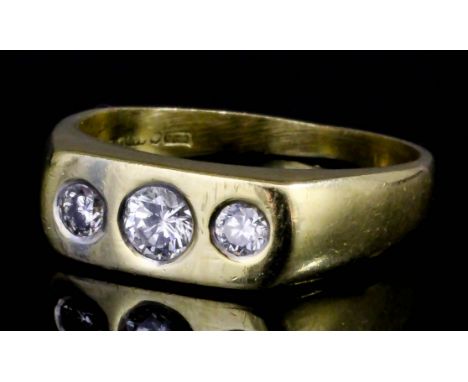 A modern 18ct gold  three stone diamond gypsy pattern ring, the flat face inset with a brilliant cut diamond of .20ct and two