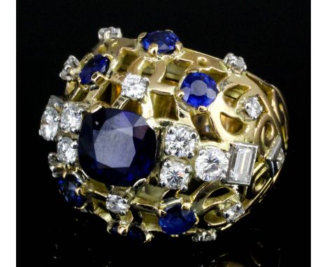 A modern gold coloured metal mounted sapphire and diamond set bombe pattern ring, the central oval cut sapphire of approximat