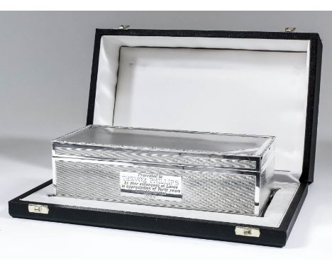 An Elizabeth II silver rectangular cigarette box with scroll cast mounts and engine turned panels to body, on bracket feet, 8