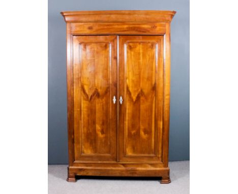 A 19th Century French cherry wood armoire with moulded cornice, enclosed by a pair of panelled doors, on bracket feet, 62ins 