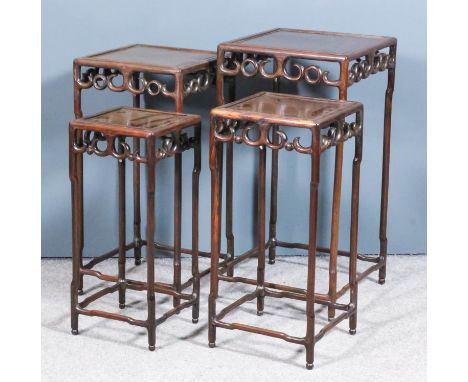 A nest of four Chinese hardwood square occasional tables with panel tops, on slender bamboo pattern legs, the aprons with fre
