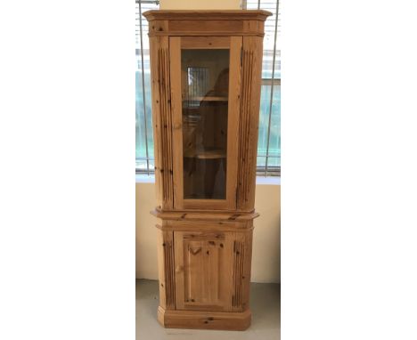 A modern pine, glass topped corner display cabinet. Top has 2 interior shaped shelves. Bottom cupboard has interior shelf. Ap