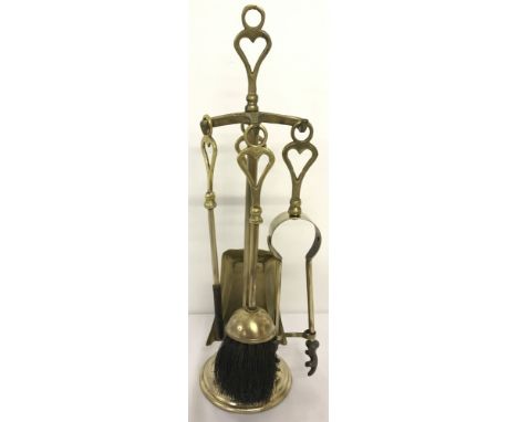 A vintage brass 5 piece companion set with heart shaped detail to handle. Comprising: poker, tongs, brush, shovel and stand. 