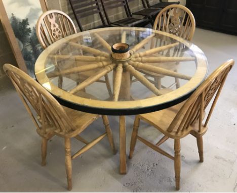 A vintage light wood, circular, glass topped, dining table made from a cart wheel. Together with 4 matching wheel back chairs