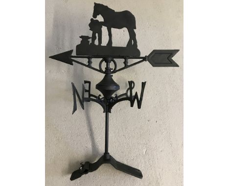 A back cast iron weather vane with horse and blacksmith detail. Complete with fixing plate. Approx. 65cm tall