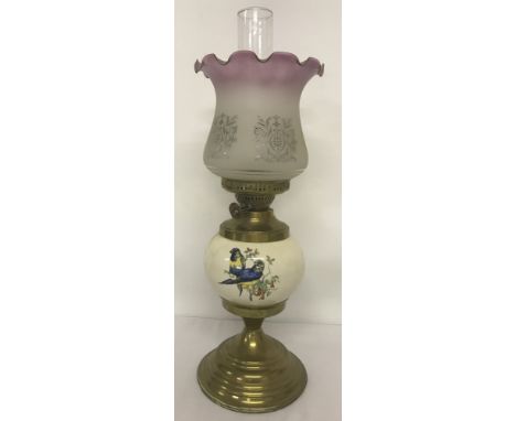 A vintage brass and ceramic oil lamp with frosted glass shade. Ceramic bowl has transfer print design with birds. Total heigh