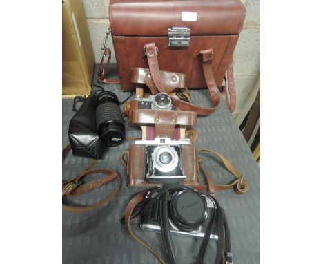 A selection of cameras and lenses in a hard camera bag. A anon AV-1, a Fed 3, a Nettar 35mm folding camera aVivitar Flash, an