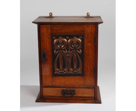 Art Nouveau smokers cabinet, with hinged top above an embossed stylised foliate copper panelled door, the interior with reces