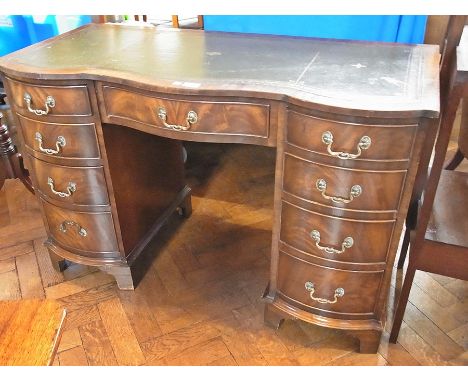 Reproduction mahogany kneehole desk having serpentine front, single frieze drawer, an arrangement of eight graduated drawers 