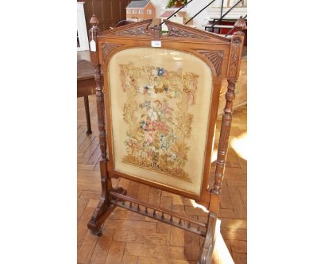 Victorian walnut firescreen with foliate carved architectural pediment flanked by pair pointed finials, with glazed panel ins