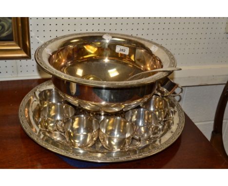 An Oneida silver plated charger, chased and engraved overall; a silver plated punch bowl, cups and ladle